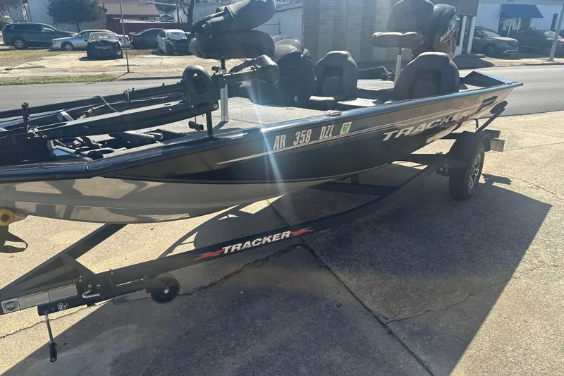Slide: The Image of 2024 Tracker Pro Team 175 TXW boat on trailer, parked outdoors in sunlight. - 2