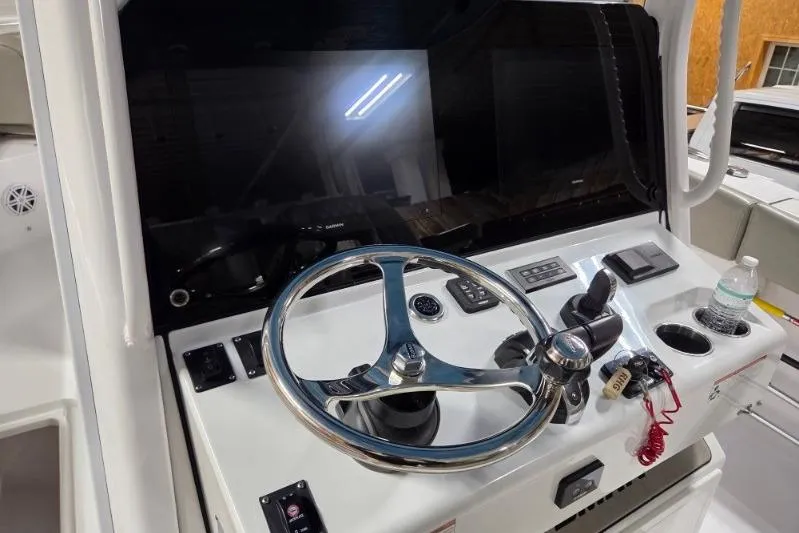 Slide: The Image of 2022 Sportsman Open 322 Center Console helm with steering wheel and controls. - 16