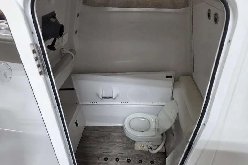 Slide: The Image of 2022 Sportsman Open 322 Center Console boat interior with compact marine toilet. - 21