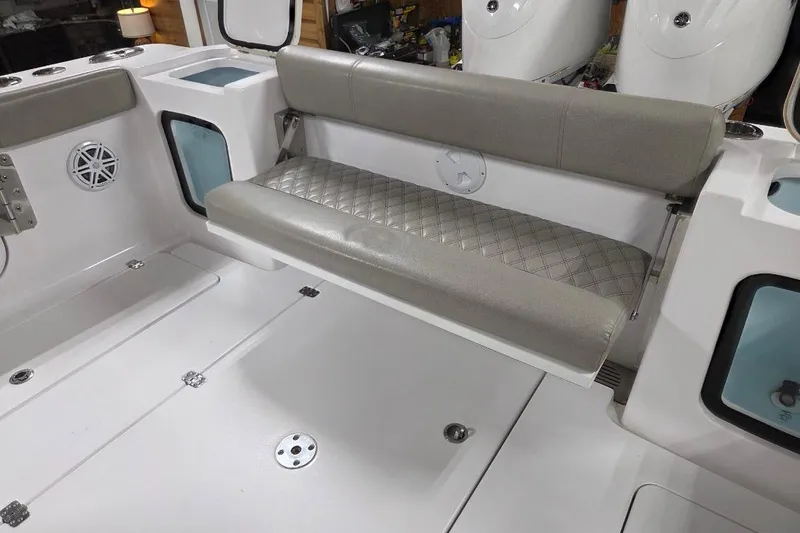 Slide: The Image of 2022 Sportsman Open 322 Center Console boat interior with cushioned seating and storage compartments. - 29