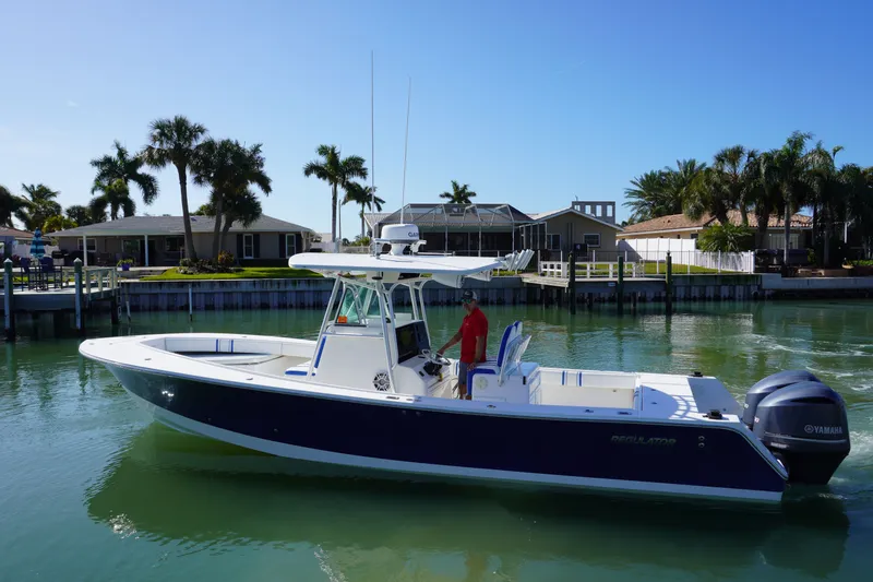 Slide: The Image of 2005 Regulator 32 boat on calm water near coastal homes. - 10