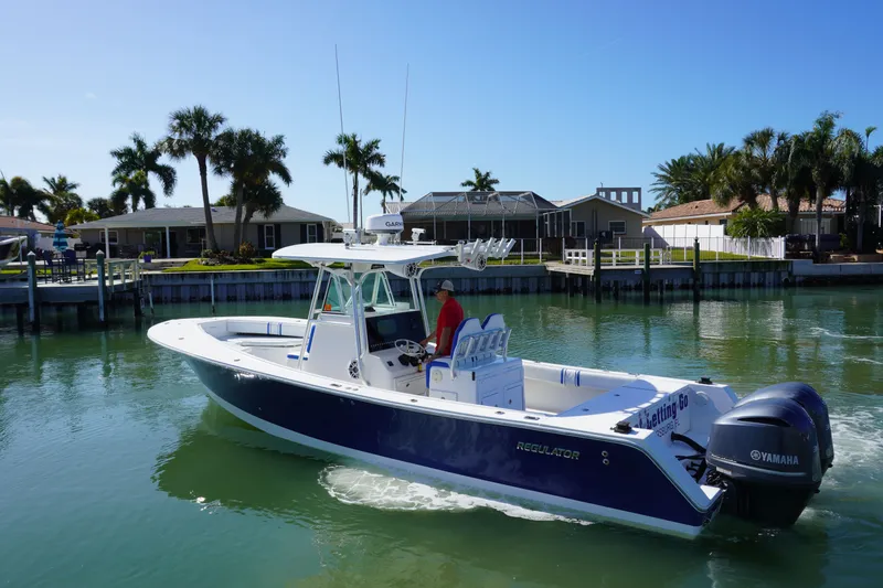Slide: The Image of 2005 Regulator 32 boat on calm water with palm trees. - 11