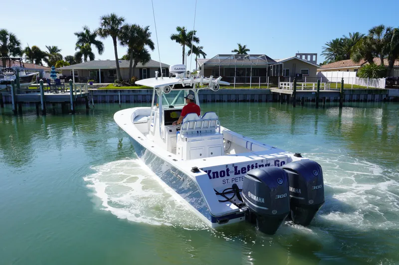 Slide: The Image of 2005 Regulator 32 boat on calm water with palm trees in the background. - 13