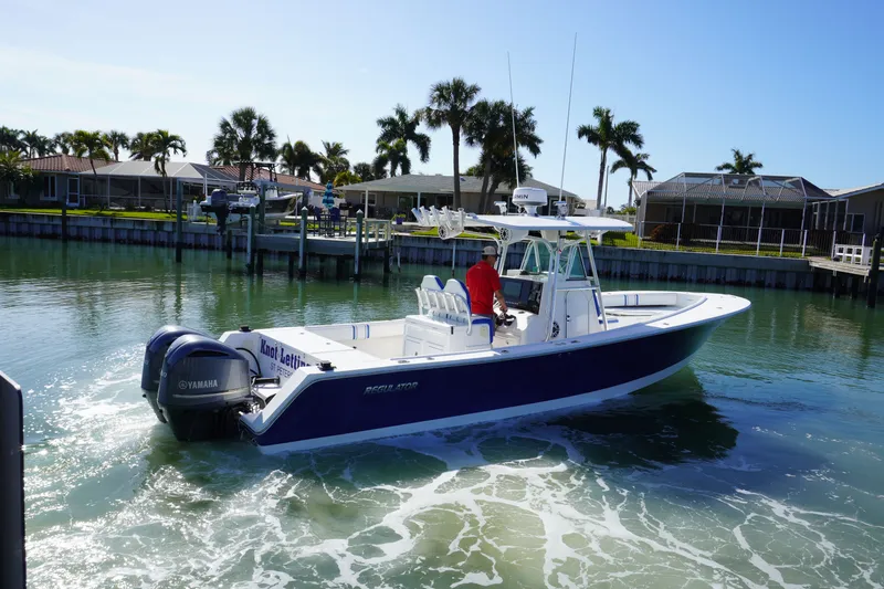 Slide: The Image of 2005 Regulator 32 boat on calm water with palm trees in background. - 18