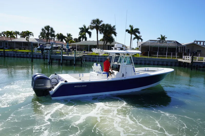 Slide: The Image of 2005 Regulator 32 boat on calm water with palm trees in background. - 19