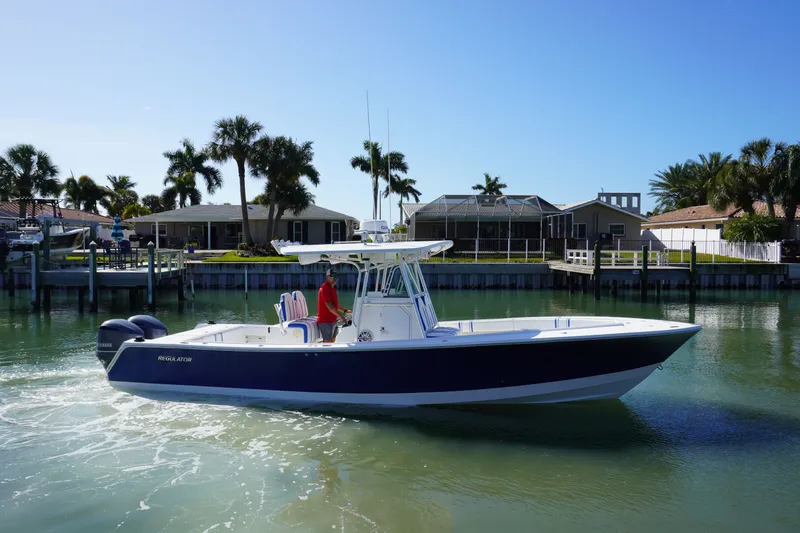 Slide: The Image of 2005 Regulator 32 boat on calm water near coastal homes. - 22