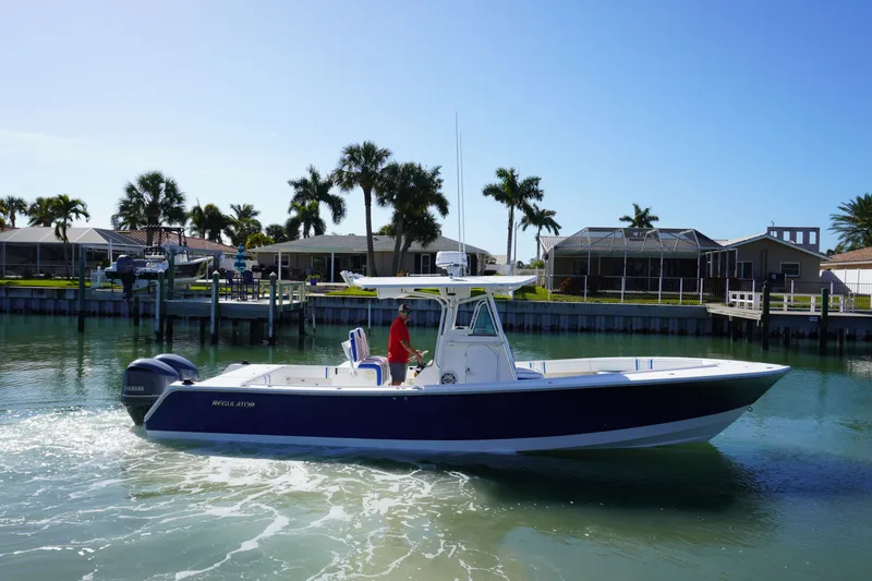 Slide: The Image of 2005 Regulator 32 boat on calm water with palm trees in background. - 26