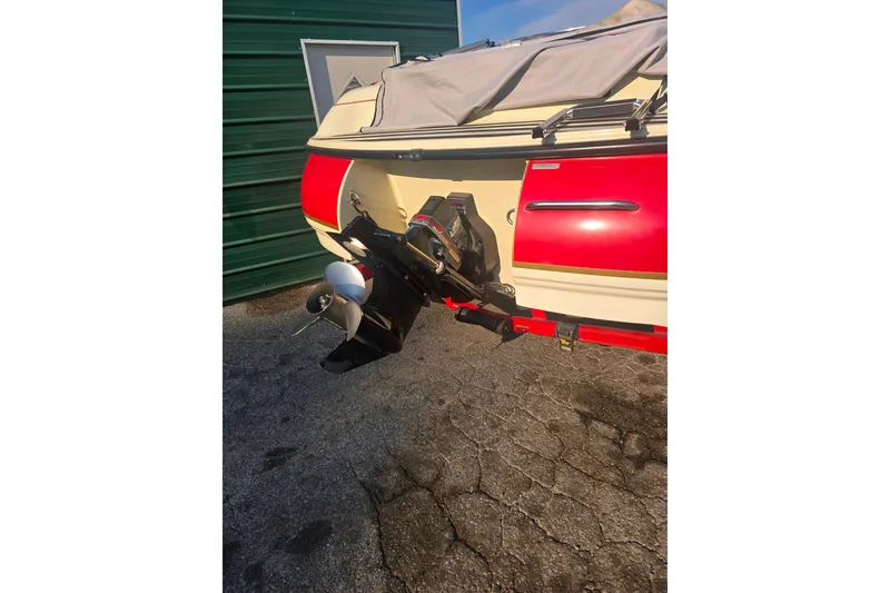 Slide: The Image of Rear view of a 1997 Bryant 182 boat with outboard motor and red accents. - 12