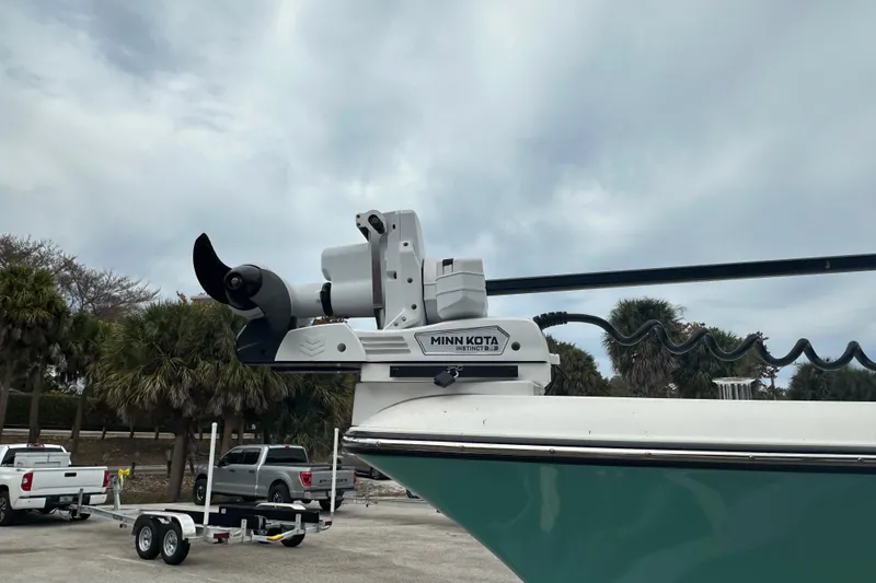 Slide: The Image of Stanley White Fishmaster 2026 boat with Minn Kota trolling motor, parked near palm trees. - 16