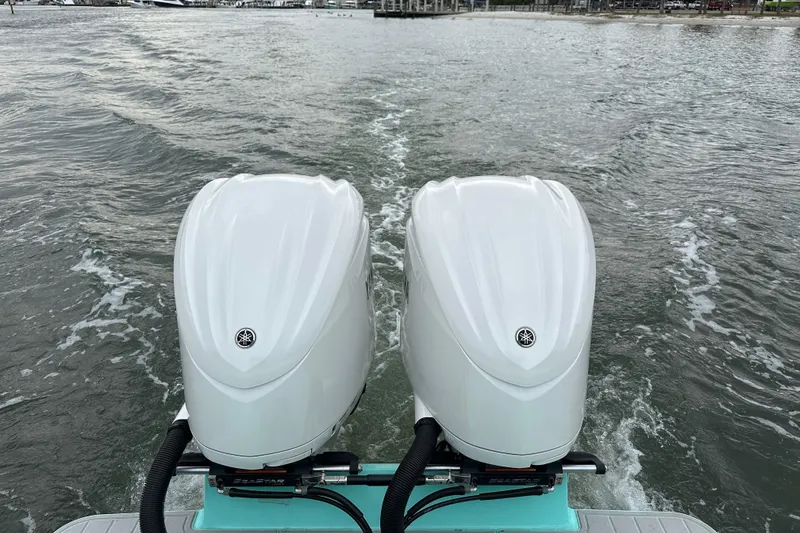 Slide: The Image of Twin outboard motors on a 2026 Stanley White Fishmaster boat navigating water. - 17
