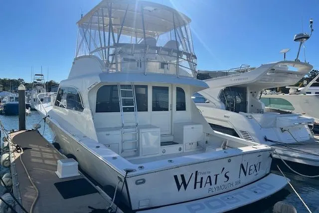 Slide: The Image of 1995 Post 50 Convertible yacht docked, featuring spacious deck and flybridge, named "What's Next." - 1