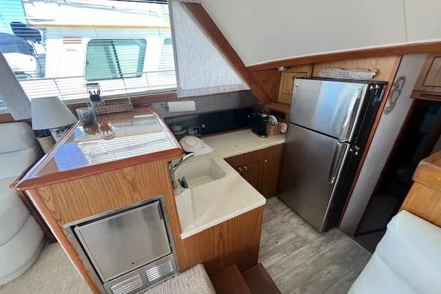 Slide: The Image of Interior of a 1995 Post 50 Convertible yacht kitchen with wood cabinetry and stainless steel appliances. - 13