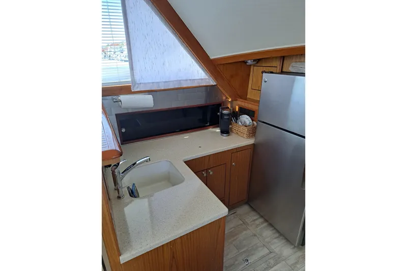 Slide: The Image of Compact kitchen in a 1995 Post 50 Convertible yacht with modern appliances and wood cabinetry. - 14