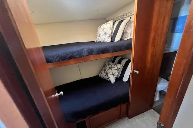 Slide: The Image of 1995 Post 50 Convertible yacht cabin with bunk beds and wooden interior. - 18