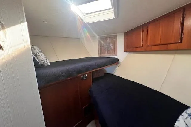 Slide: The Image of 1995 Post 50 Convertible cabin interior with twin beds and wooden cabinets. - 19
