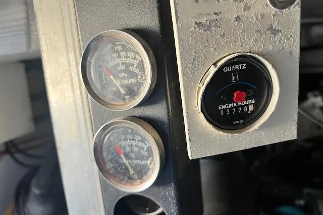 Slide: The Image of Close-up of 1995 Post 50 Convertible engine gauges showing pressure, temperature, and engine hours. - 24
