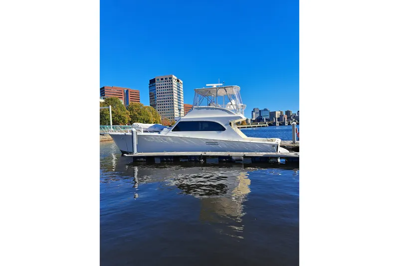 Slide: The Image of White 1995 Post 50 Convertible yacht docked in urban marina with city skyline backdrop. - 4