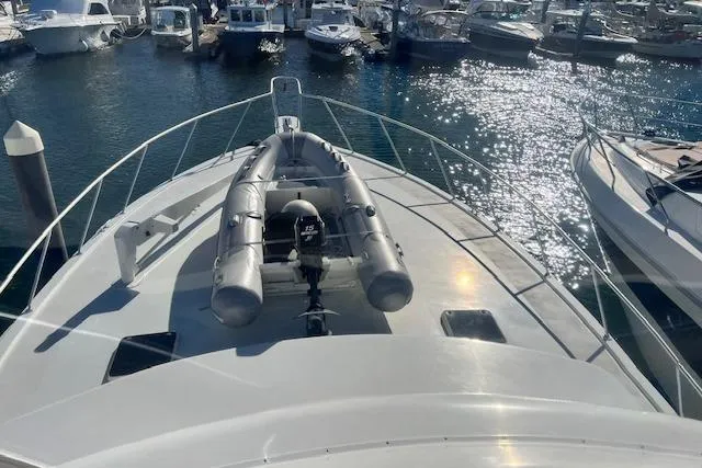 Slide: The Image of 1995 Post 50 Convertible yacht with inflatable boat on deck, docked in a marina. - 6