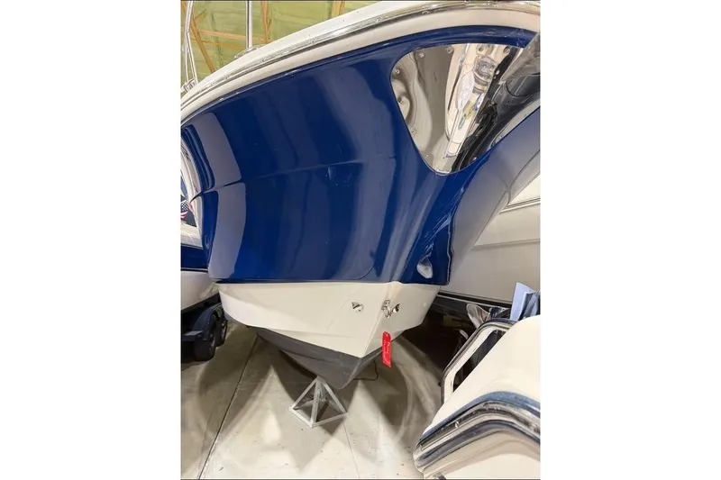 Slide: The Image of 2008 Chaparral Signature 270 boat hull in storage, featuring a sleek blue and white design. - 5