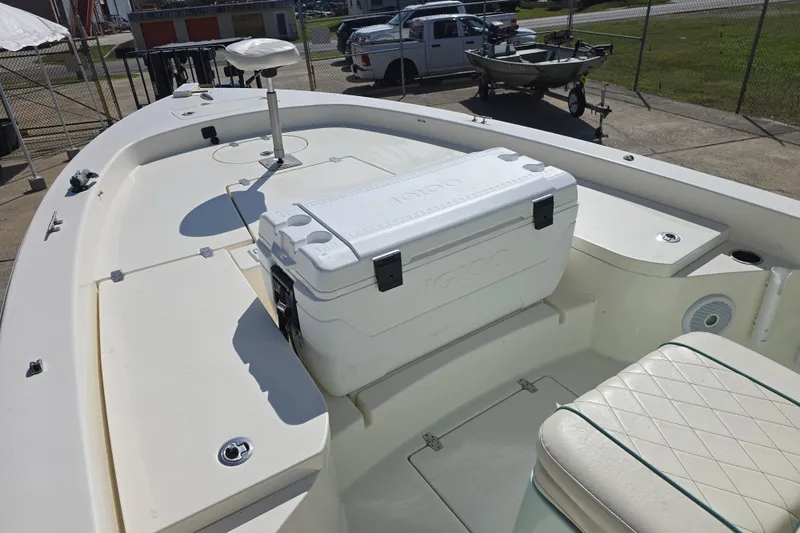 Slide: The Image of 2016 Pathfinder 2600 HPS boat deck with seating and cooler, parked outdoors. - 4