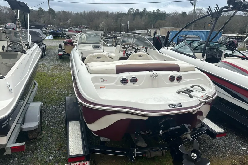 Slide: The Image of 2005 Tahoe Q4 Sport boat on trailer, parked among other boats in a lot. - 10
