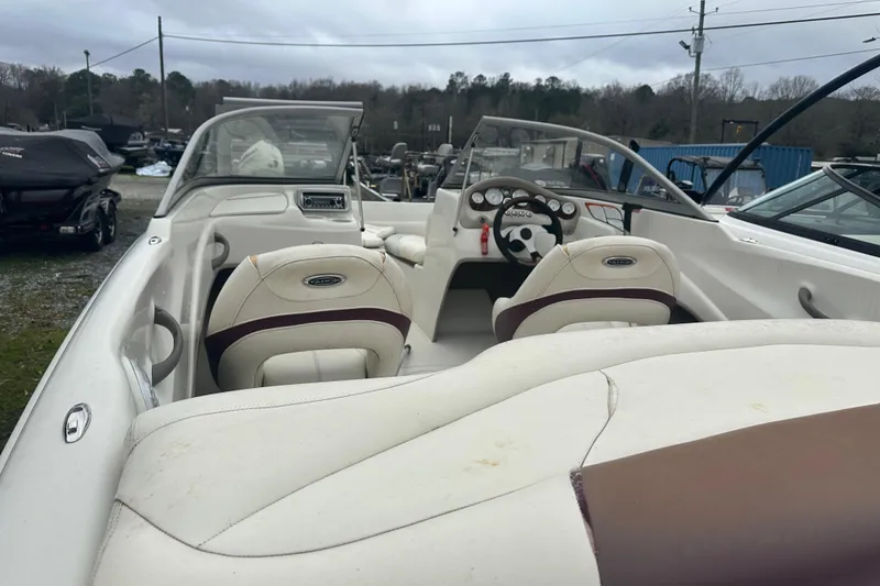 Slide: The Image of 2005 Tahoe Q4 Sport boat interior with white and brown seating, steering wheel, and dashboard. - 11