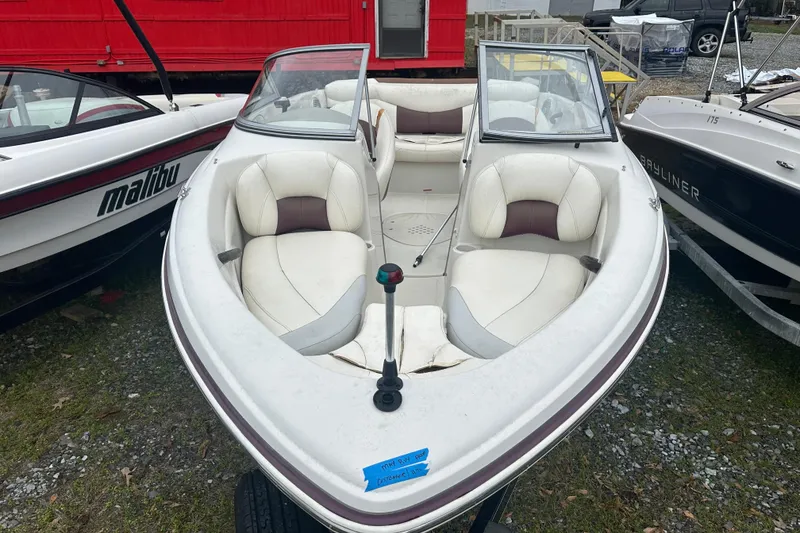 Slide: The Image of 2005 Tahoe Q4 Sport boat with white and brown seating, parked outdoors. - 2