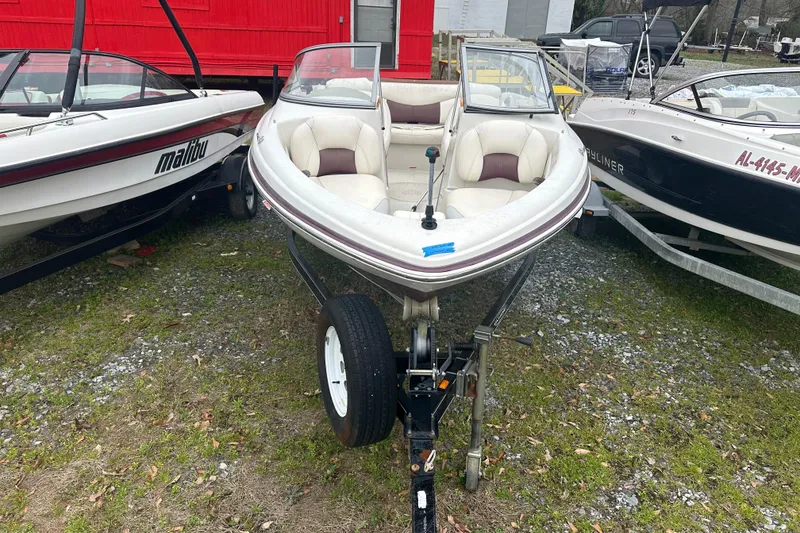 Slide: The Image of 2005 Tahoe Q4 Sport boat on trailer, parked between two other boats. - 3