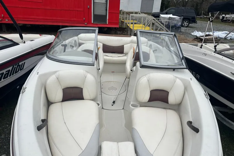 Slide: The Image of 2005 Tahoe Q4 Sport boat with white and brown seating, parked outdoors. - 5