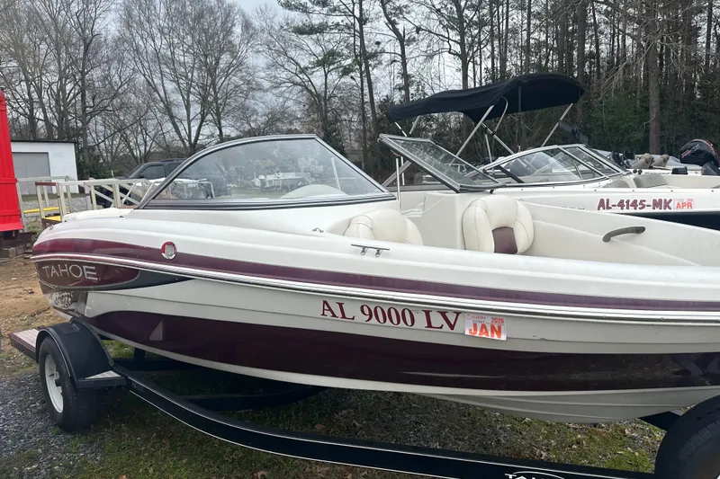 Slide: The Image of 2005 Tahoe Q4 Sport boat on trailer, parked outdoors with trees in background. - 7