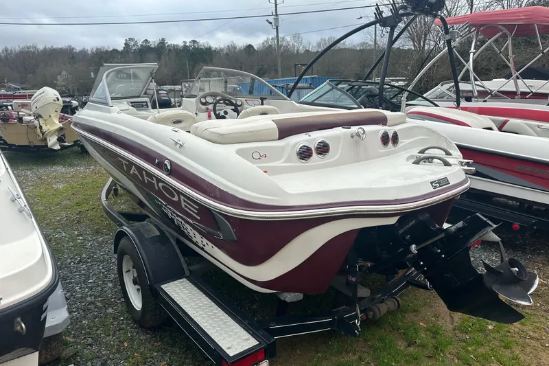 Slide: The Image of 2005 Tahoe Q4 Sport boat on trailer, parked outdoors among other boats. - 9