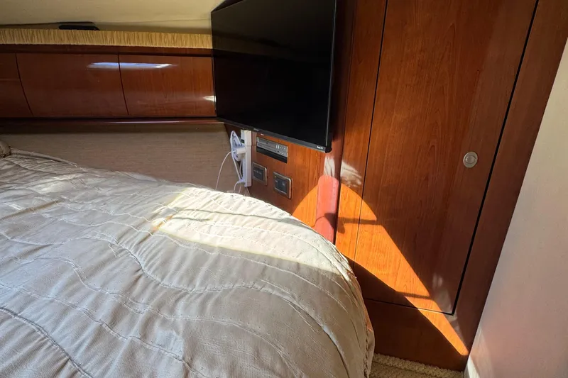 Slide: The Image of Interior of 2005 Sea Ray 420 Sundancer with wood paneling and mounted TV. - 12
