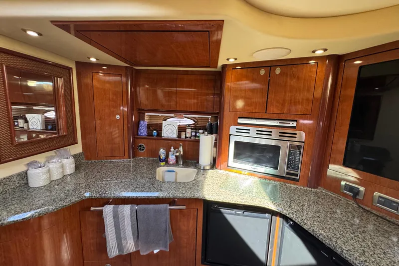 Slide: The Image of Luxurious 2005 Sea Ray 420 Sundancer yacht kitchen with granite countertops and wood cabinetry. - 8