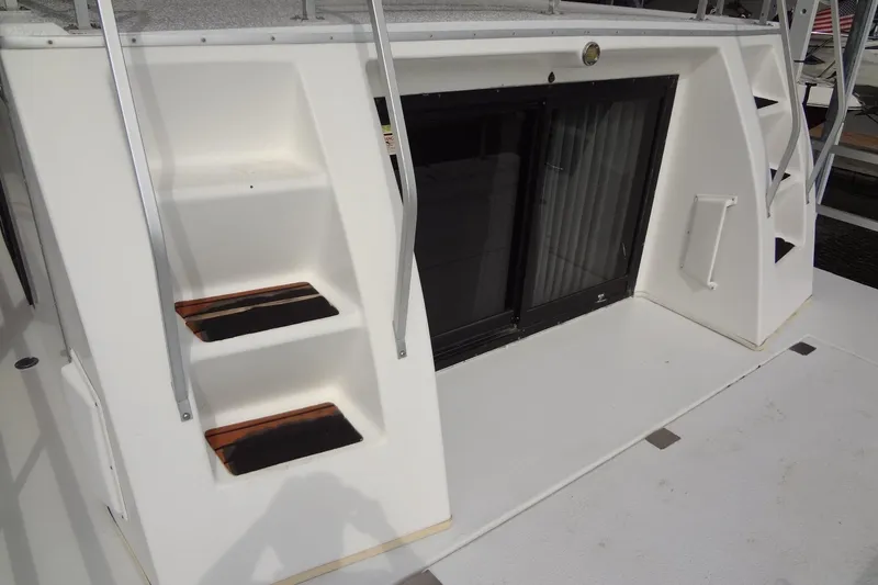 Slide: The Image of 2005 Gibson 44 boat with white exterior, stairs, and sliding glass door. - 15