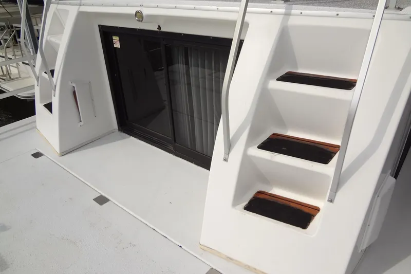 Slide: The Image of 2005 Gibson 44 boat with white exterior stairs and sliding glass door. - 16