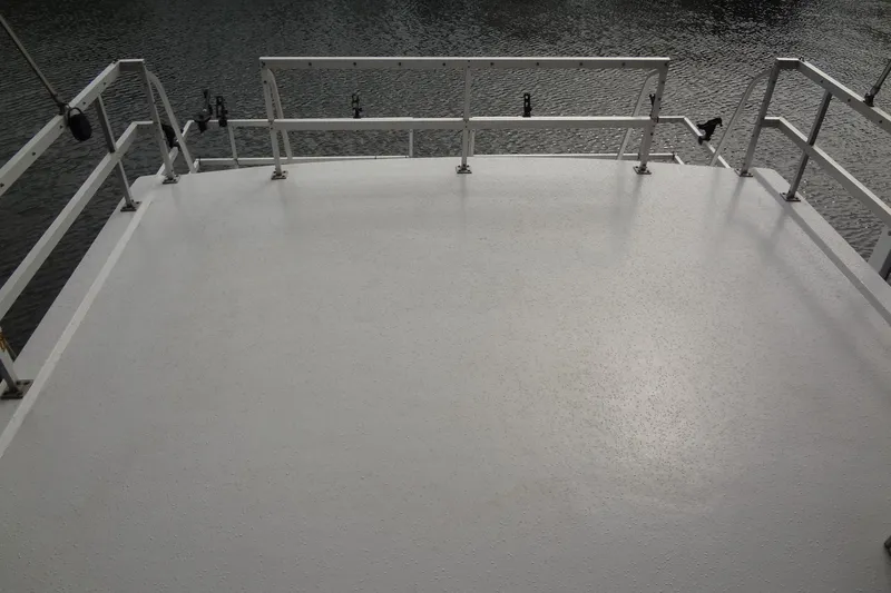 Slide: The Image of Gibson 44 boat deck, 2005 model, with white surface and railing, overlooking water. - 17