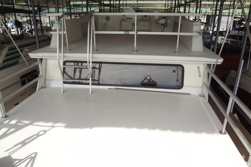 Slide: The Image of 2005 Gibson 44 boat deck with railing and ladder in marina. - 18