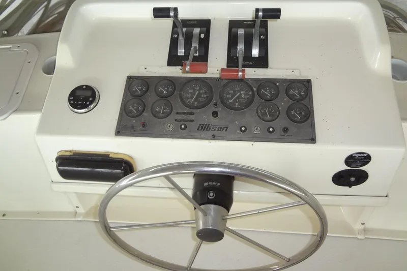 Slide: The Image of Control panel of a 2005 Gibson 44 boat with steering wheel and gauges. - 20