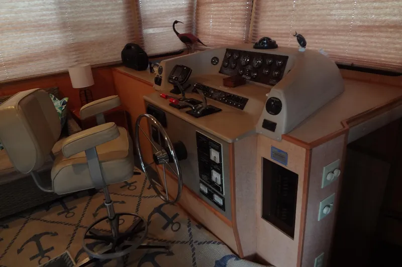 Slide: The Image of 2005 Gibson 44 boat helm with steering wheel, control panel, and captain's chair. - 21