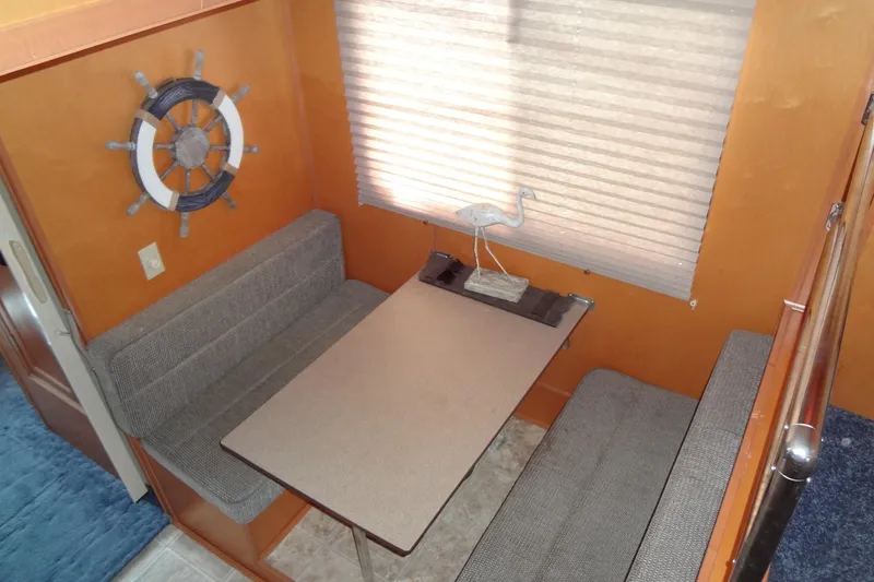 Slide: The Image of Cozy dining area in 2005 Gibson 44 boat with nautical decor and window blinds. - 29