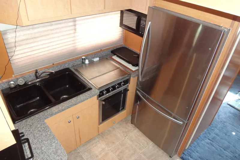 Slide: The Image of Compact kitchen in a 2005 Gibson 44, featuring stainless steel appliances and granite countertops. - 31