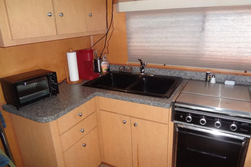 Slide: The Image of Compact kitchen with sink, stove, toaster oven, and cabinets in a 2005 Gibson model 44. - 32