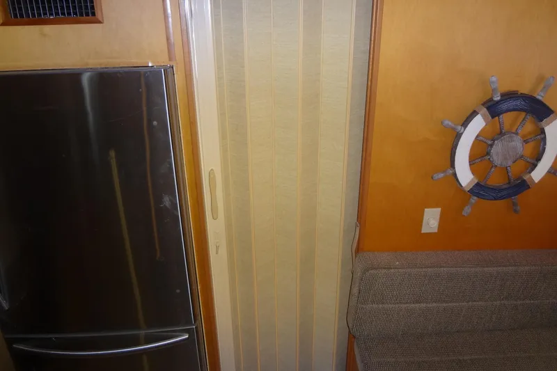 Slide: The Image of Interior of 2005 Gibson 44 boat with fridge, helm decor, and seating. - 35