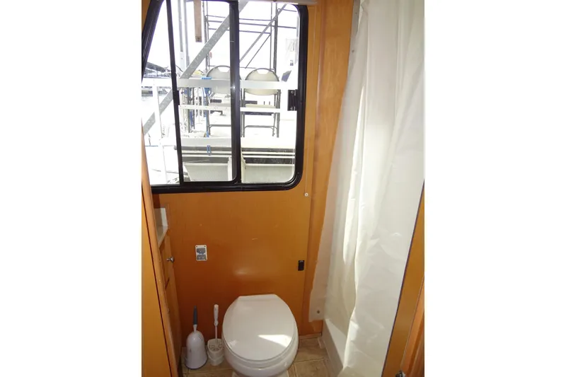 Slide: The Image of 2005 Gibson 44 boat bathroom with window, toilet, and shower curtain. - 40
