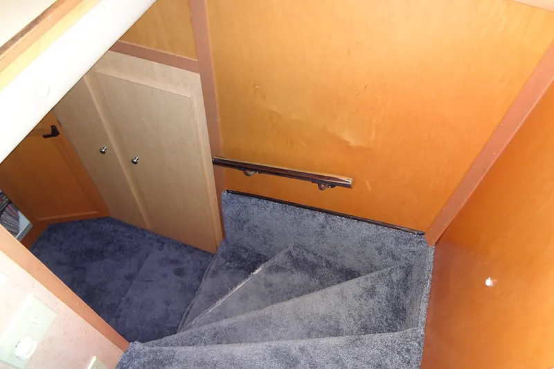 Slide: The Image of Staircase with blue carpet and wooden walls in a 2005 Gibson 44 model. - 42
