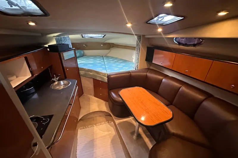 Slide: The Image of 2000 Chaparral Signature 300 cabin interior with kitchenette, seating area, and sleeping space. - 17