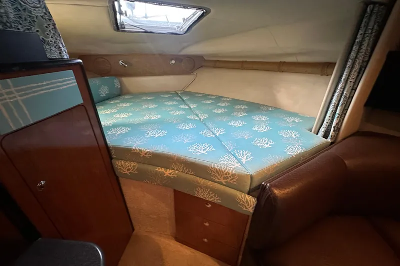 Slide: The Image of Interior cabin of 2000 Chaparral Signature 300 with patterned bedding and wood accents. - 22