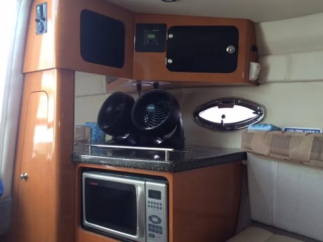 Slide: The Image of 2007 Chaparral 275 SSi boat interior with microwave and fans on countertop. - 5