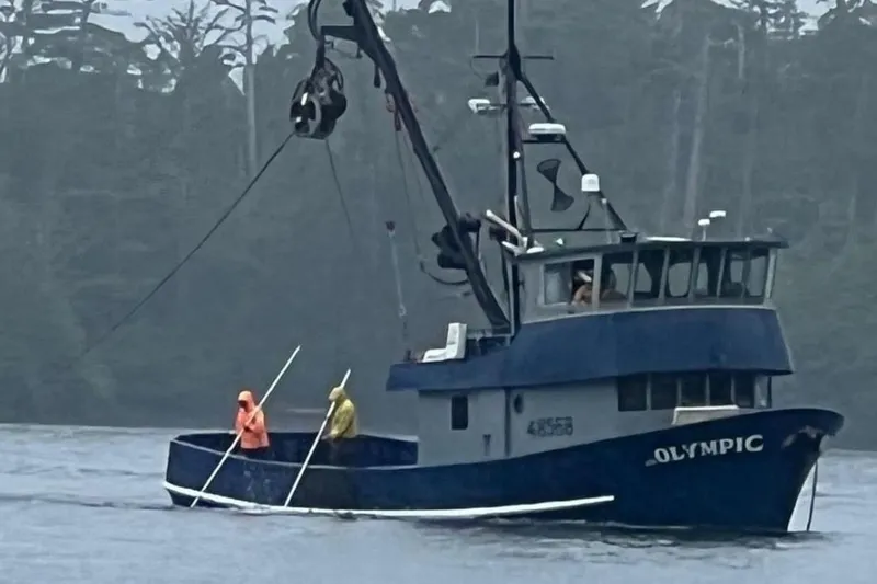 Slide: The Image of 1976 Custom 54 Steel Fishing Vessel "Olympic" on water with crew in rain gear. - 3