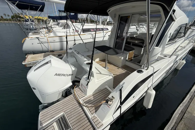 Slide: The Image of 2021 Beneteau Antares 8 boat docked, featuring a Mercury outboard engine. - 18